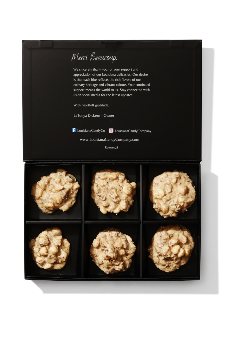 A box of individually wrapped toasted coconut and macadamia nut pralines with visible nuts and coconut pieces.